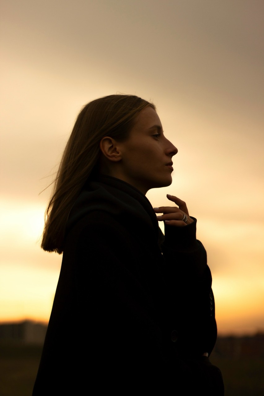Woman looks with hope to the sunset